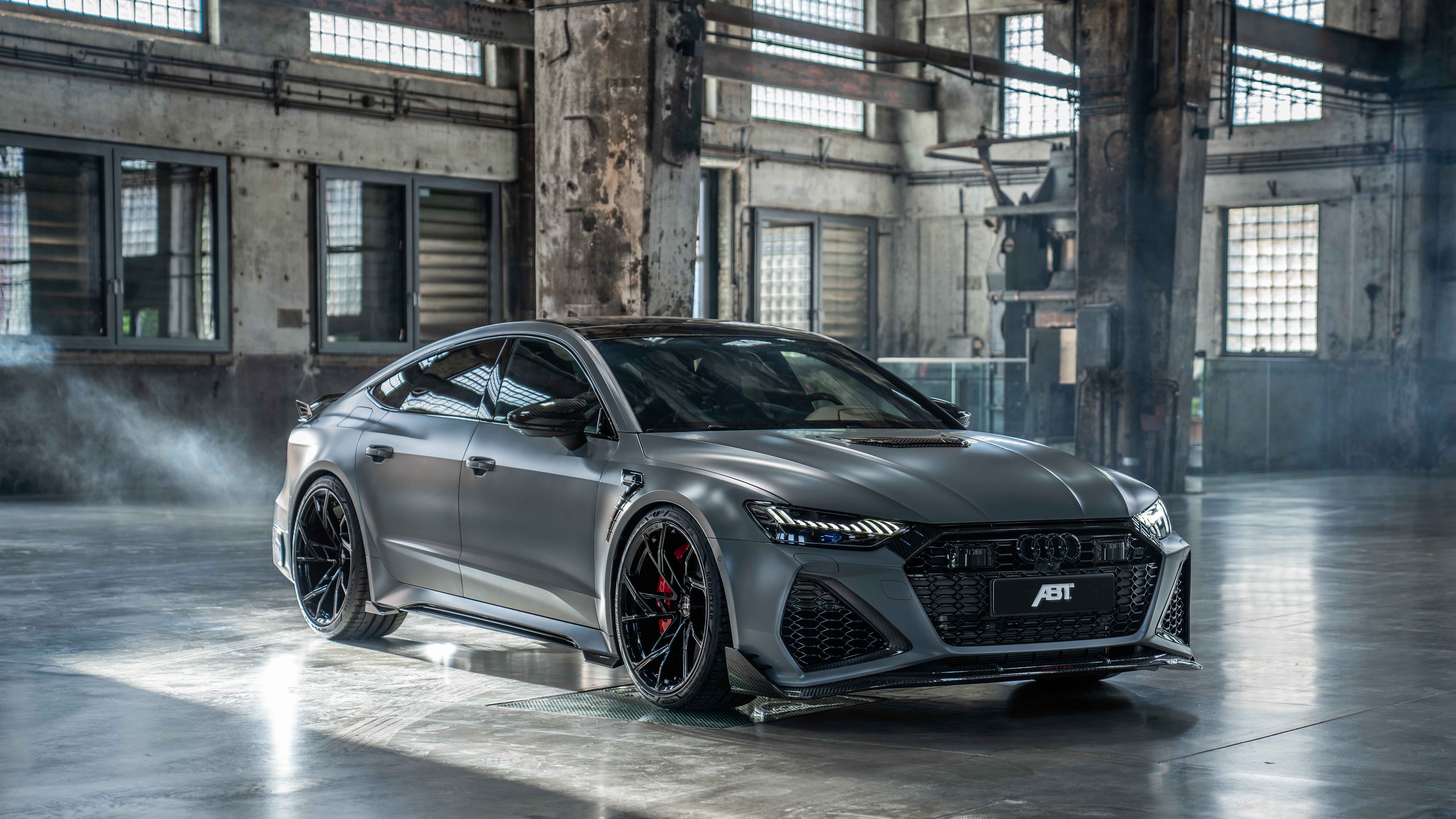 Un Audi RS7 de alto rendimiento, un sedán con una carrocería elegante y metálica y un diseño de rejilla delantera imponente.