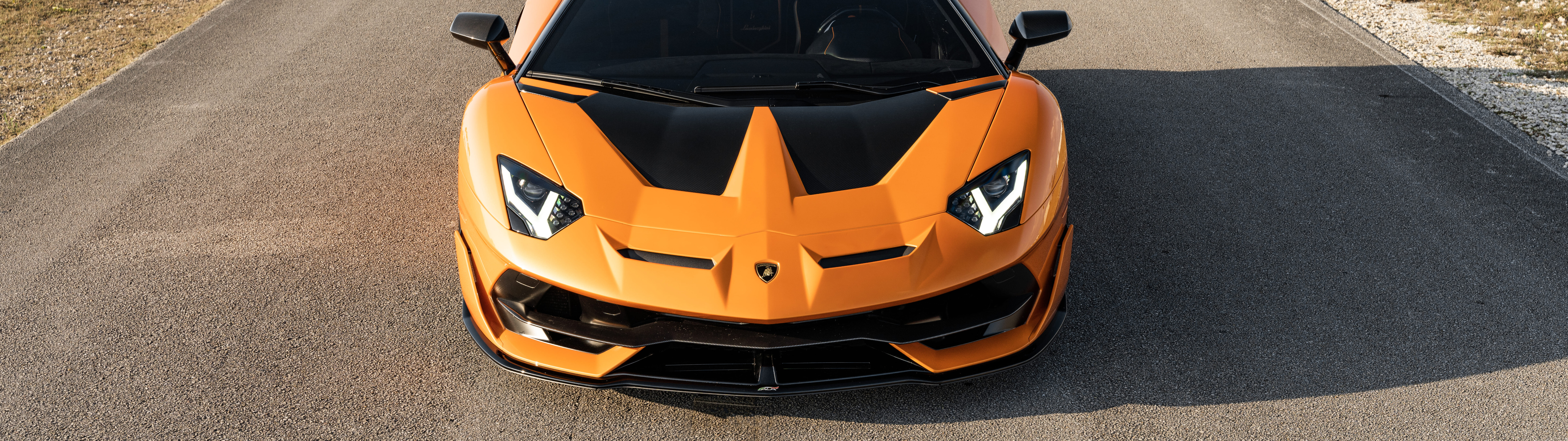 Una vista en primer plano de un Lamborghini Aventador SVJ, que muestra su elegante diseño aerodinámico y la imponente silueta de este superdeportivo.