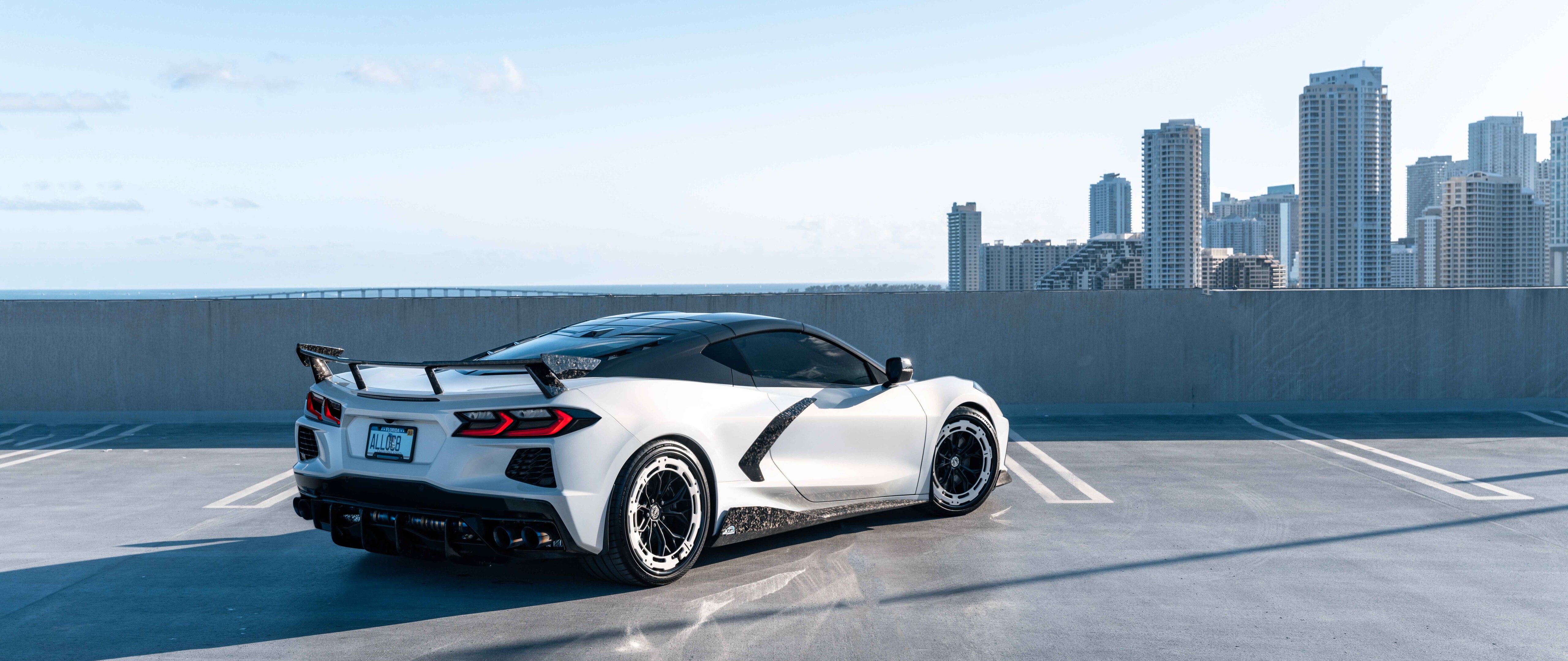 Una vista detallada de un Chevrolet Corvette C8, un coche deportivo que destaca por su carrocería aerodinámica y su diseño moderno.