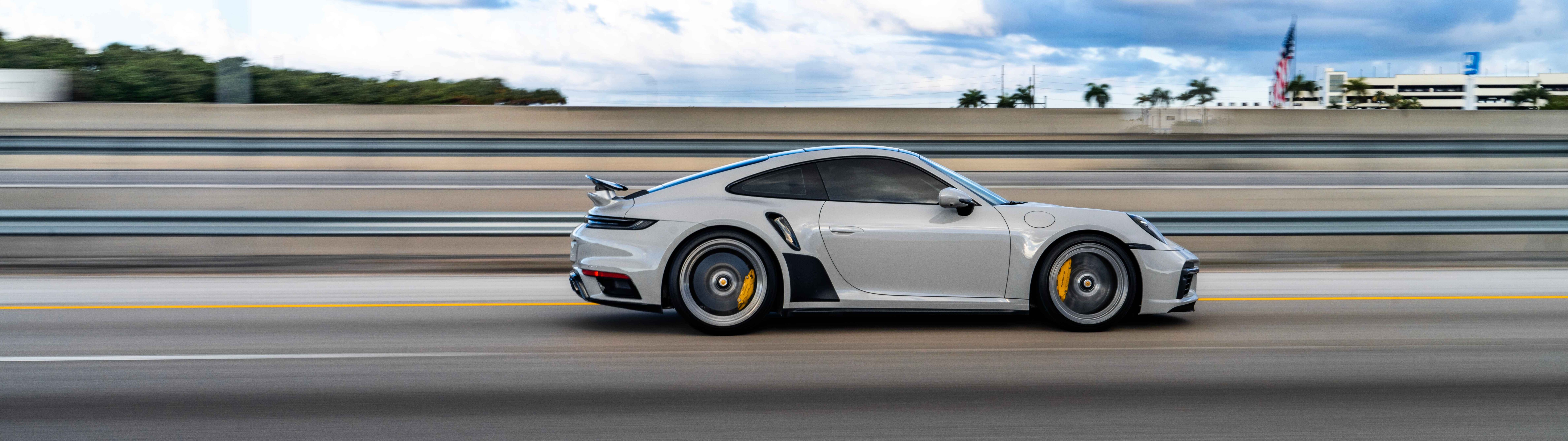 Una imagen en primer plano de un lujoso coche deportivo Porsche, que destaca por su diseño elegante y su acabado metálico.