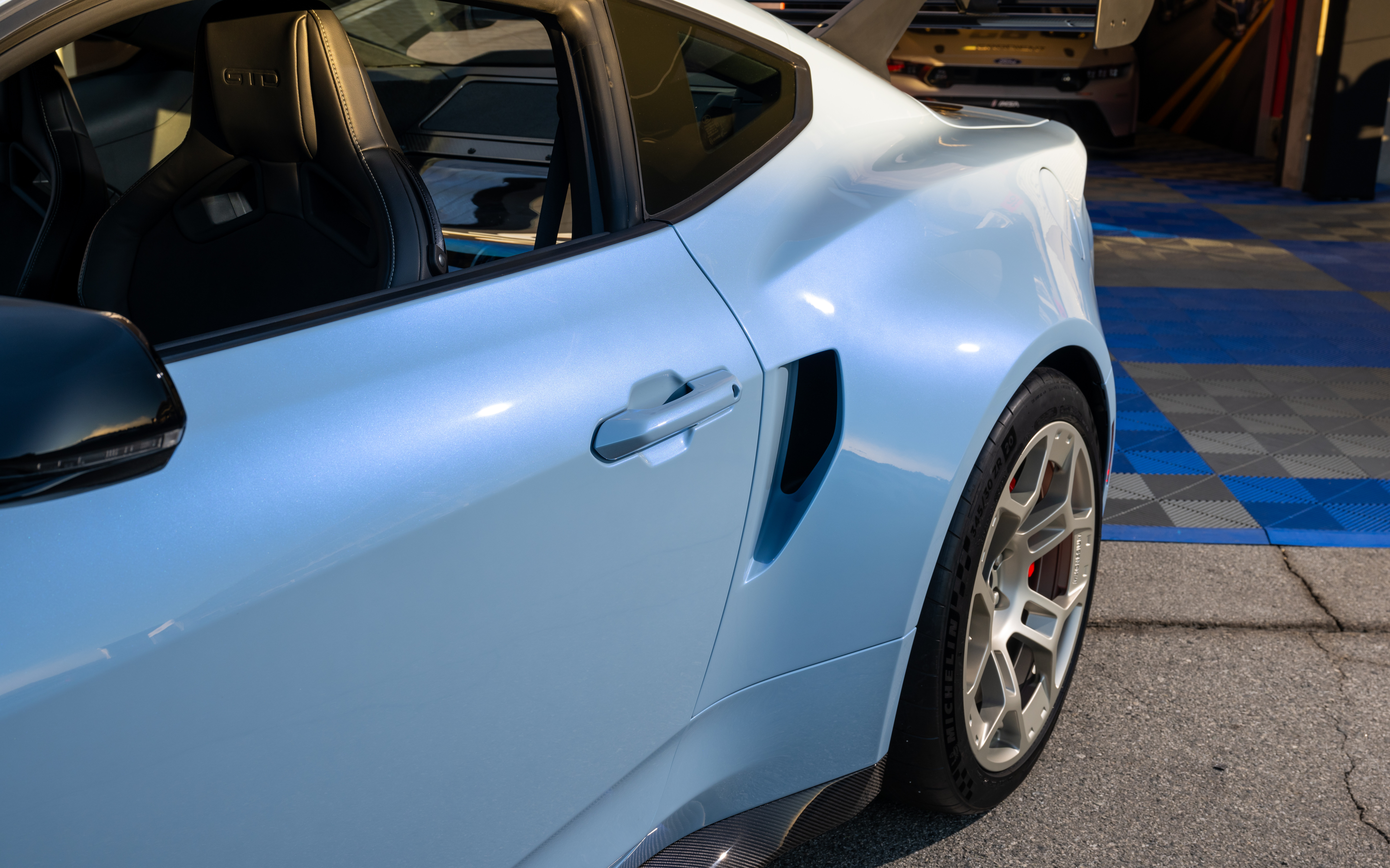 Una imagen detallada de un Ford Mustang GTD que muestra su diseño aerodinámico y agresivo, así como su kit de carrocería ensanchada.